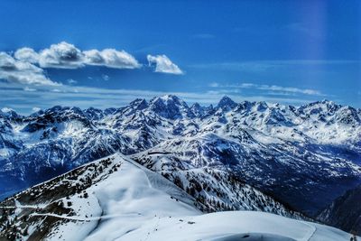 Scenic view of snowcapped mountains against blue sky