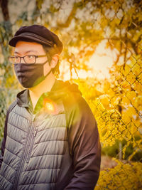 Portrait of young man standing by plants