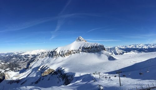 Snow covered mountain against blue sky