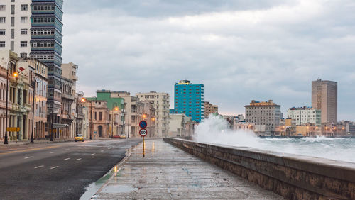 Road amidst buildings against sky in city