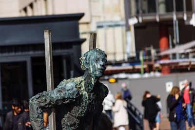 Close-up of statue against city