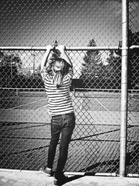 Man standing on chainlink fence