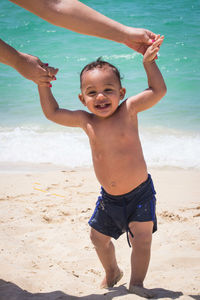 Rear view of shirtless boy at beach