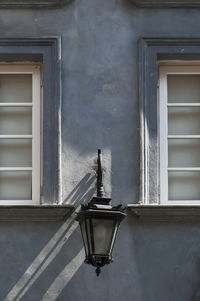 Low angle view of electric lamp on wall of building