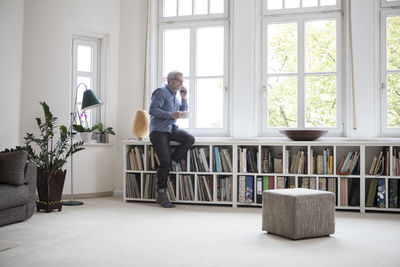 Mature man at home on the phone