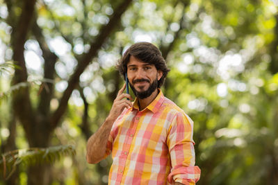 Young man at park on a beautiful sunny day with mobile phone.  working  leisure. green and nature 