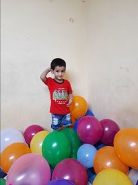 Full length of smiling girl standing against multi colored wall