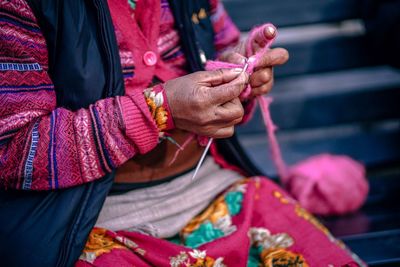 Midsection of woman knitting wool