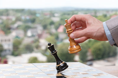 Close-up of hand holding chess pieces on table