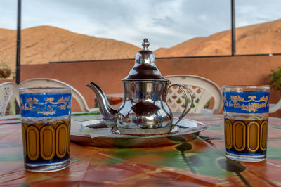 Glasses and kettle with mountain in background