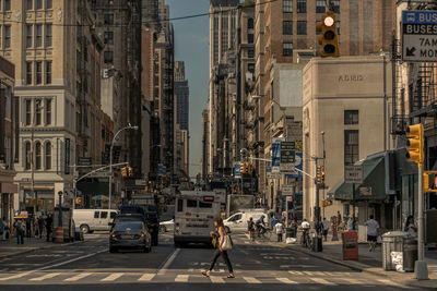 Side view of woman walking on zebra crossing in city