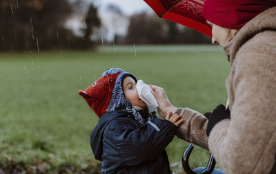 Close-up of mother and son on field