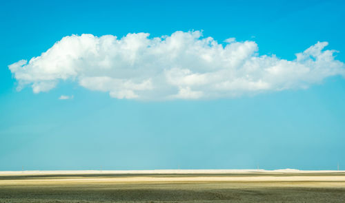 Scenic view of beach against blue sky