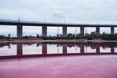 Bridge over river in city against sky