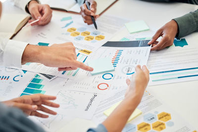 Midsection of business people working on table