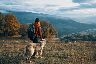 Rear view of man with dog on mountain