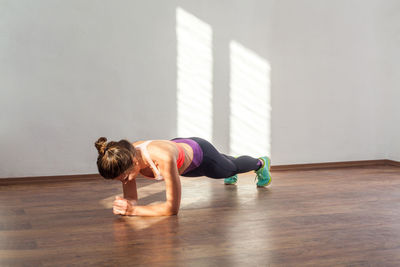 Full length of woman lying on hardwood floor