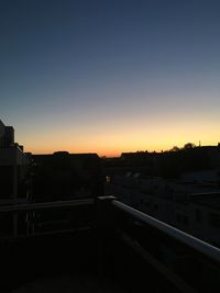 High angle view of city buildings against clear sky during sunset