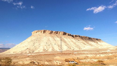 Rock formations on landscape against blue sky