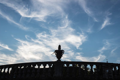 Rear view of silhouette man standing by railing against sky