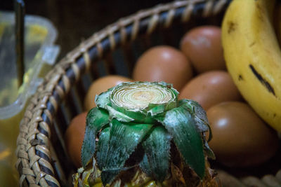 Close-up of pineapple, eggs, and banana in the basket