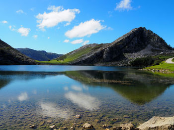 Scenic view of lake and mountains against blue sky