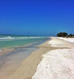 Scenic view of beach against blue sky