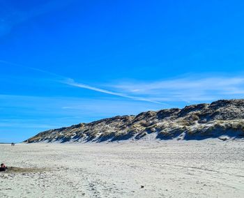 Scenic view of beach against blue sky