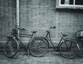 Bicycle parked against brick wall