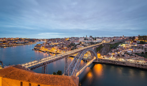 High angle view of dom luis i bridge over river by illuminated buildings in city