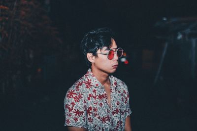 Young man wearing sunglasses at night