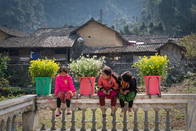 People outside house against buildings