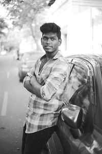 Portrait of young man standing in car