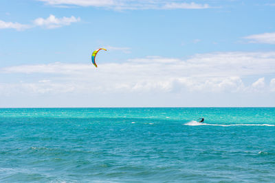 View of a unrecognizable person kiteboarding on the ocean against clear sky