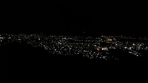 High angle view of illuminated buildings against sky at night