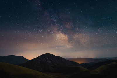 Scenic view of mountains against sky at night