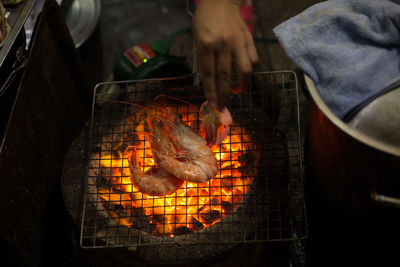 High angle view of hand preparing food on barbecue grill