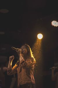 Woman holding illuminated light painting at night