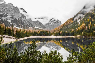 Scenic view of lake and mountains against sky during winter