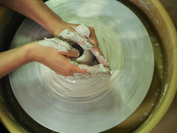Cropped hand of person working with pottery