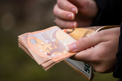 Close-up of hand holding paper