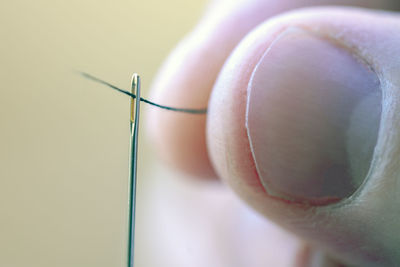 Close-up of thread inserting in needle