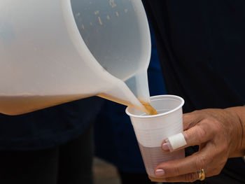 Midsection of man holding coffee cup