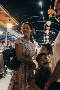 Happy parents and children at food market on vacation