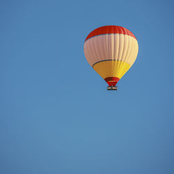 Lonely hot air balloon flies in blue sky.