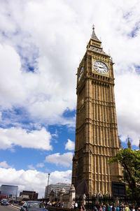 Low angle view of clock tower against cloudy sky