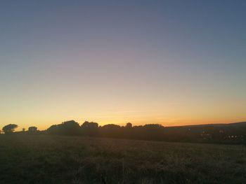 Scenic view of landscape against clear sky at sunset