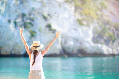 Rear view of woman standing by sea