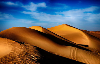 Sand dunes in desert against sky