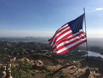 American flag on landscape against sky